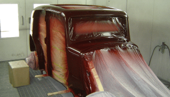 A classic car body is being spray painted at the Classic Car workshop, Upper Classics NZ.
