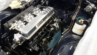 A restored classic car engine gleems by Upper Classics NZ.