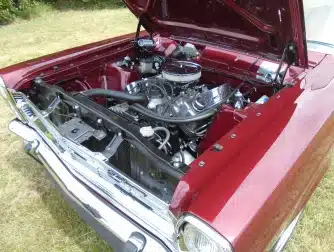 Red sports car with bonnet up showing a classic car engine repaired by Upper Classics NZ